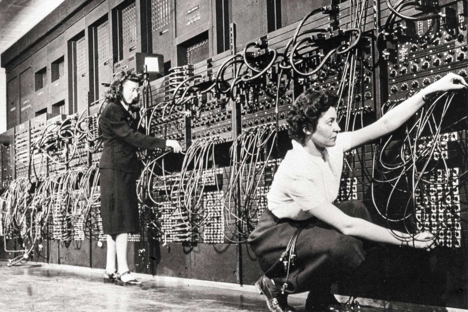 Programmerare kopplar kablar och vrider rattar på ENIAC